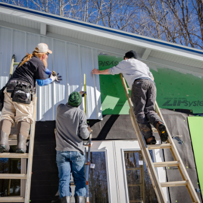 three construction contractors building a home